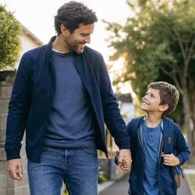 Vater geht mit Schulkind